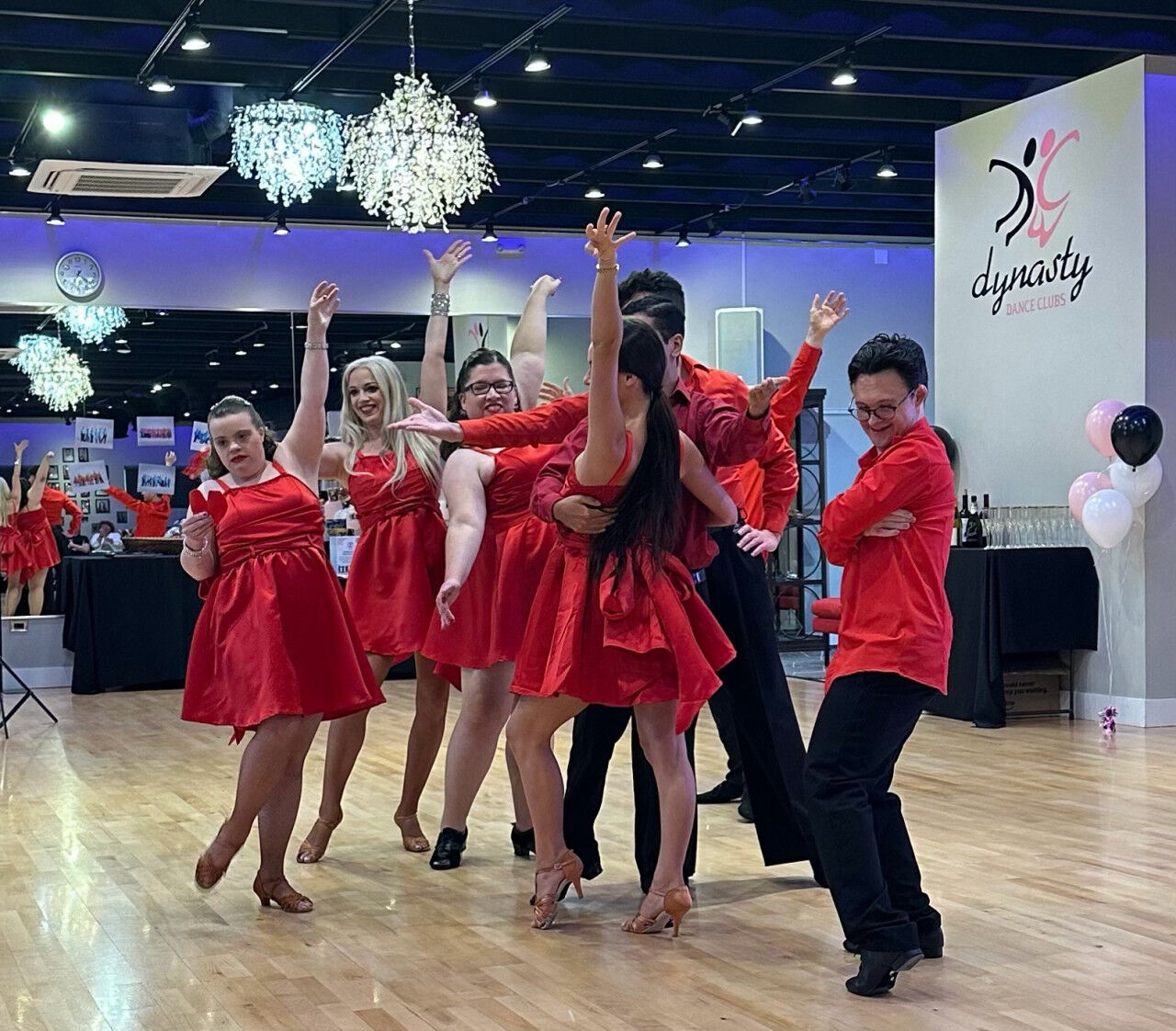 Dancers in red performing a showcase under the chandeliers